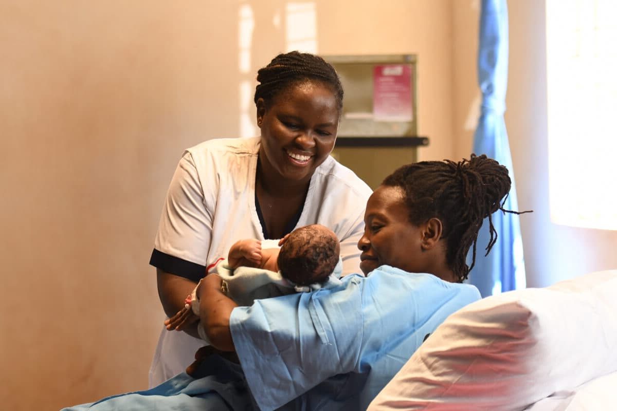 Amref Health Africa verloskundige met moeder en kind